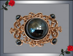 Vintage Filigree Brooch with a rich dark gray domed mirror-finished center stone