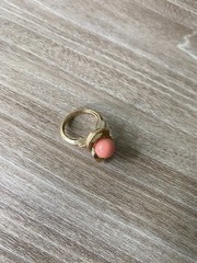 Avon vintage gold toned ring showcasing a single faux coral-colored bead.